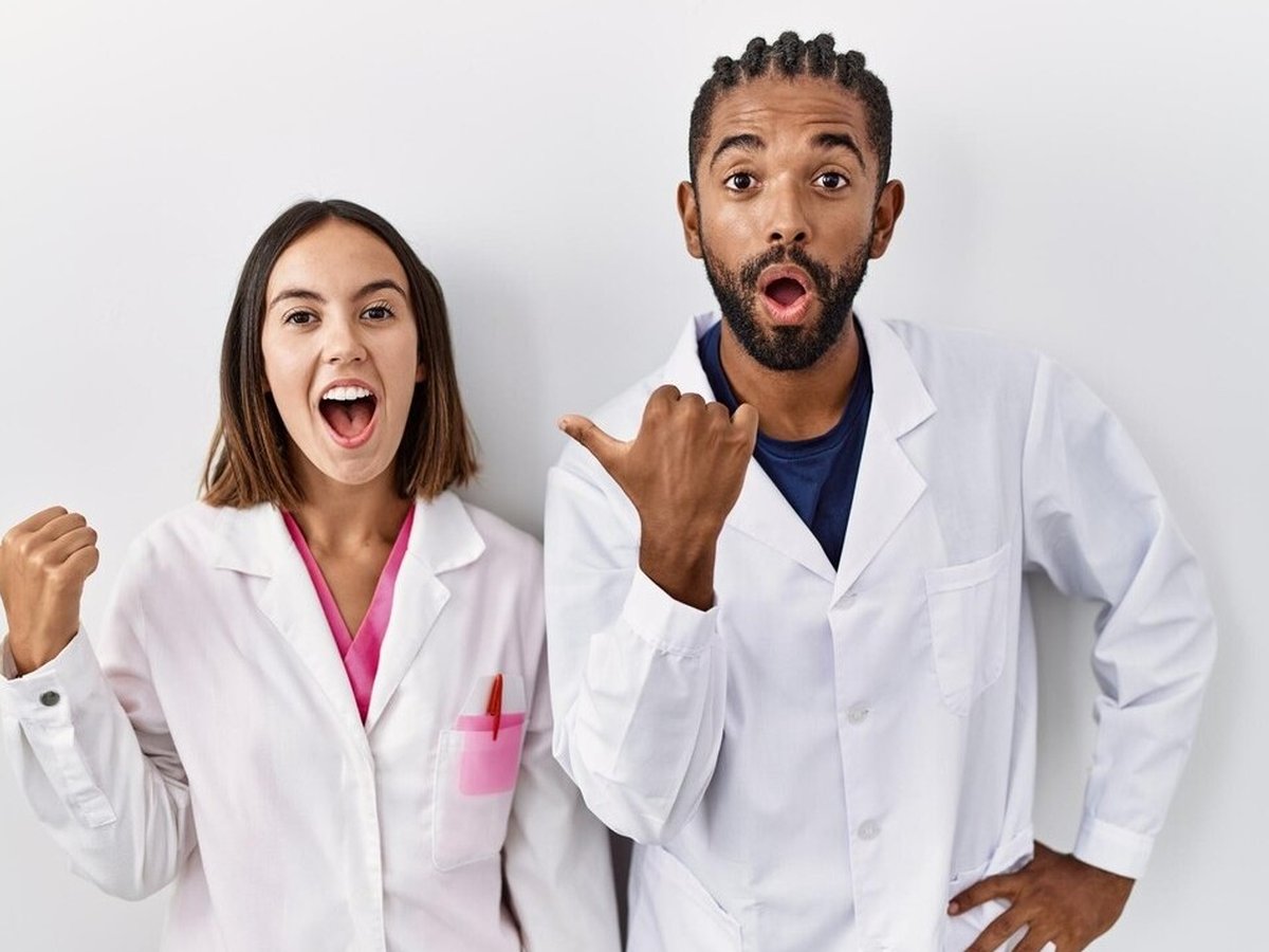Deux professionnels en blouse, souriants, présentant les solutions d'Hygiène Antilles